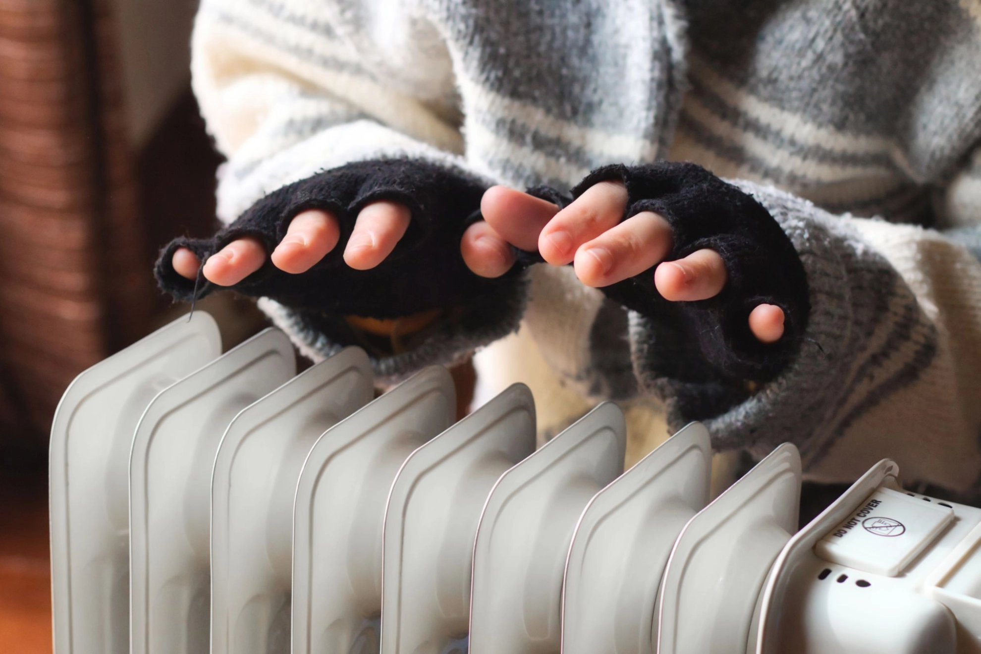 Hände über Heizkörper wärmen